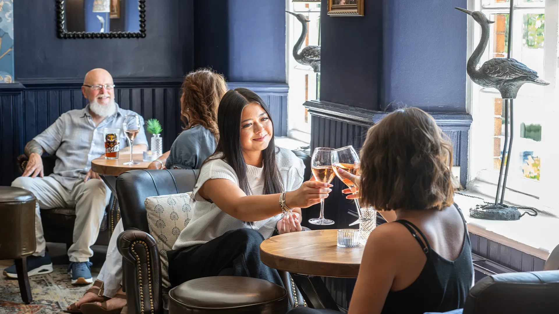 Friends raising wine glasses together in a welcoming local pub